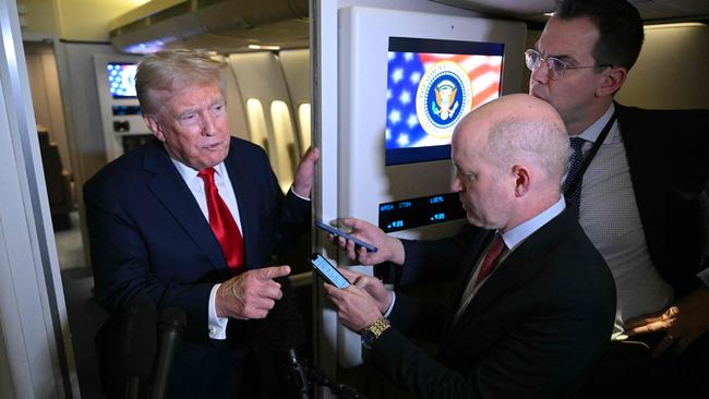 Donald Trump speaks to reporters on board Air Force One. Picture; AFP.