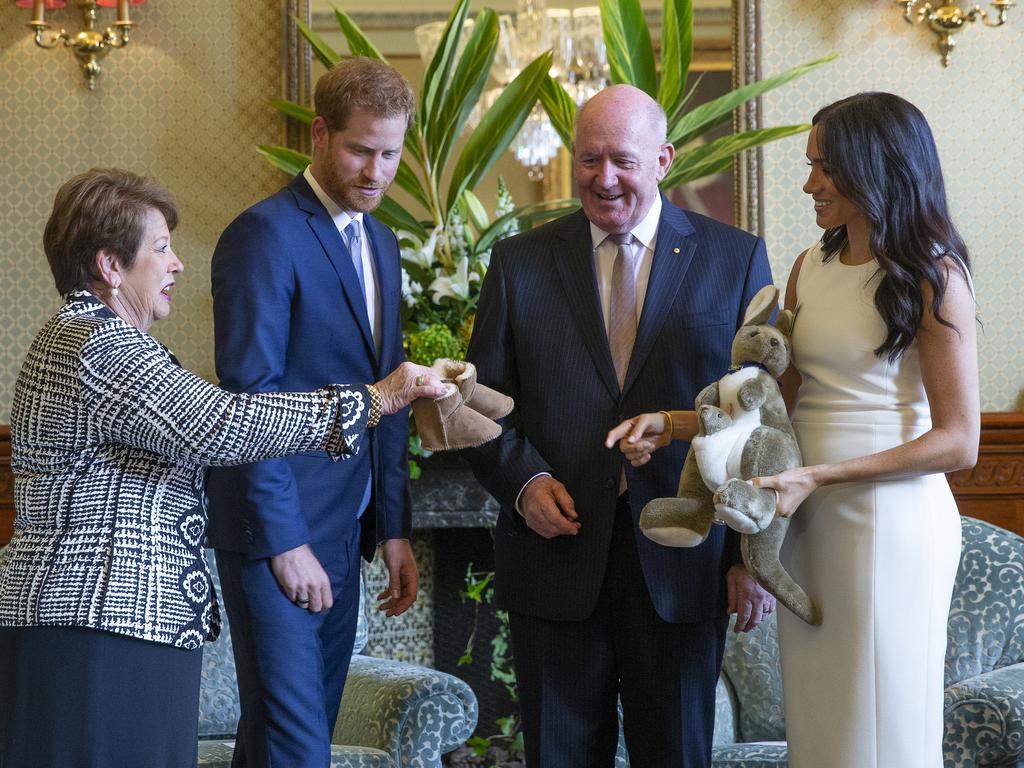 Governor-General Sir Peter Cosgrove and his wife Lady Lynne Cosgrove present a toy kangaroo and a pair of small Ugg boots to Harry and Meghan.