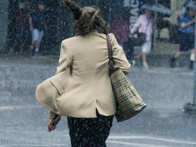 CBD workers caught short without a brolly at the intersection of George and Turbot Streets as rain dumps on the Brisbane CBD. Picture: NewsWire / Glenn Campbell