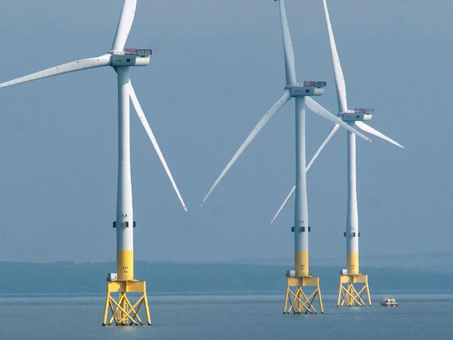 (FILES) A ferry navigates past wind turbines off the coast of Aberdeen in the North East of Scotland, on April 29, 2022. In Europe's oil and gas 