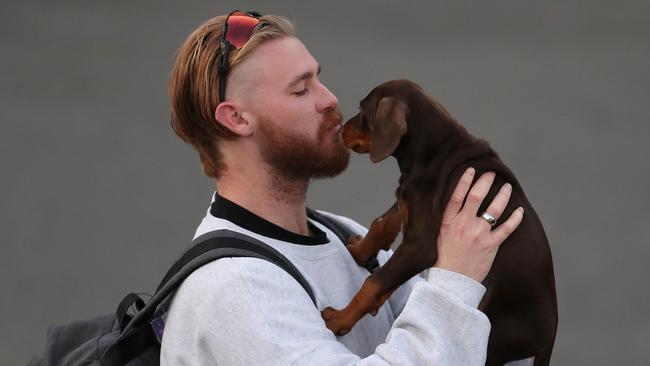 Cam McCarthy kisses his pup goodbye as he joins fellow Fremantle Dockers players leaving Perth for the Gold Coast on Tuesday. Picture: Getty Images