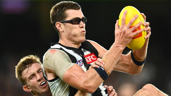 Mason Cox of the Magpies claims a mark. Photo by Quinn Rooney/Getty Images