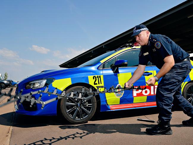 Road Policing Superintendent Daniel Shean demonstrates the Stinger tire deflation device that is being rolled out to NT Police officers on the front line.