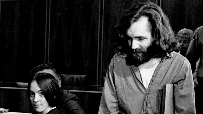 In this Oct. 13, 1970 file photo, cult leader Charles Manson walks into the courtroom as Susan Atkins, a member of his family of followers, looks on in Santa Monica, Calif. Atkins was expected to succumb to brain cancer months ago, but the former Charles Manson follower imprisoned for killing actress Sharon Tate nearly four decades ago still clings to life. Now, a hearing that is perhaps her last chance at freedom has been abruptly put off until September, 2009. (AP Photo/File)