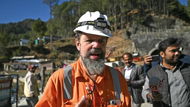 Independent disaster investigator and President of the International Tunnelling and Underground Space Association Arnold Dix (C), is pictured near the Silkyara under construction road tunnel, days after it collapsed in the Uttarkashi district of India's Uttarakhand state on November 21, 2023. Forty-one Indian workers trapped in a collapsed road tunnel for 10 days were seen alive on camera on November 21, for the first time, looking exhausted and anxious, as rescuers attempted to create new passageways to free them. (Photo by Arun SANKAR / AFP)