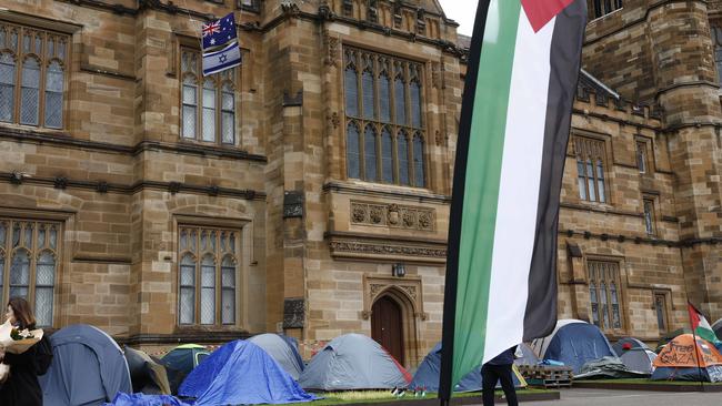 A lone Israeli flag twinned with an Australian flag, above the tent set up at the pro-Palestine encampment at Sydney University, in May 2024. Picture: Richard Dobson