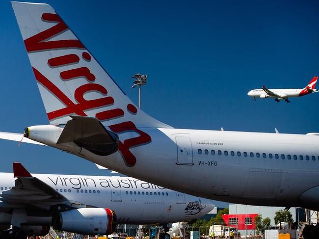 Virgin Australia aircraft are seen parked on the tarmac at Brisbane International airport. The 250-plus jobs on the line are in head office with more lay-offs to come. Picture: AFP