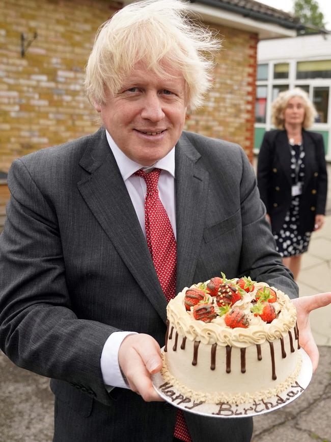 Boris Johnson holding a birthday cake presented to him by the staff during a socially distanced visit to Bovingdon Primary School in Bovingdon in June 2020/ There are claims Johnson broke lockdown rules by having a birthday party at Downing Street on June 19, 2020.