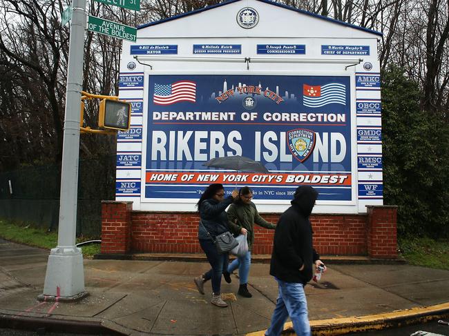 People walk by a sign at the entrance to Rikers Island in New York City. Picture: AFP