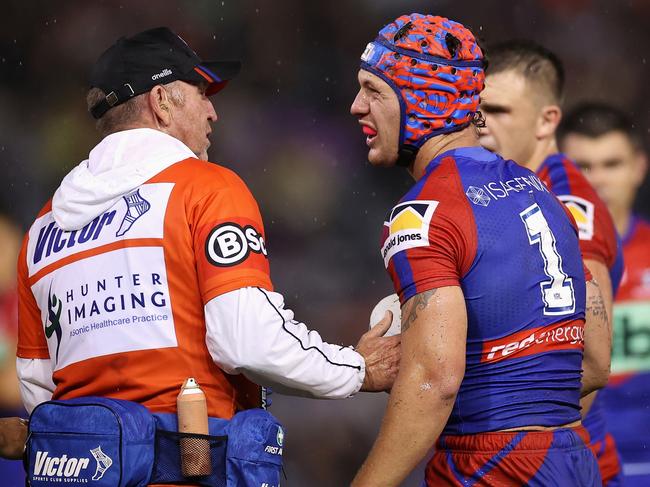 Kalyn Ponga of the Knights receives attention after he hit the turf hard in a tackle. Picture: Cameron Spencer/Getty Images