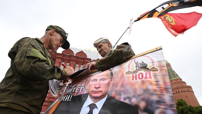 Activists hold a portrait of Russian President Vladimir Putin near Red Square in Moscow. Picture: AFP