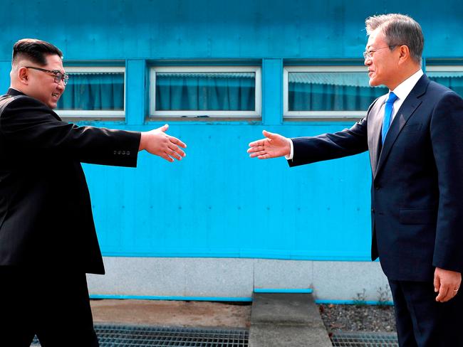 The Korean leaders shake hands over the military demarcation line at the border village of Panmunjom in the Demilitarised Zone. Picture: Korea Summit Press Pool/AP