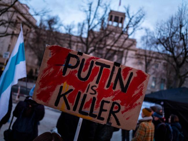 A demonstrator displays a placard reading 'Putin is (a) killer' during a protest against Russia's invasion of Ukraine, in front of the Russian Embassy in Berlin on April 2, 2022. (Photo by John MACDOUGALL / AFP)