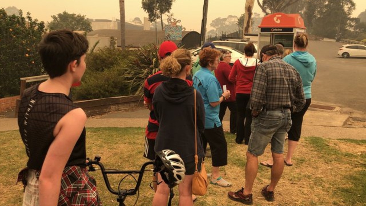 Bushfire-affected residents line up to use public phone. Picture: Jade MacMillan/ABC