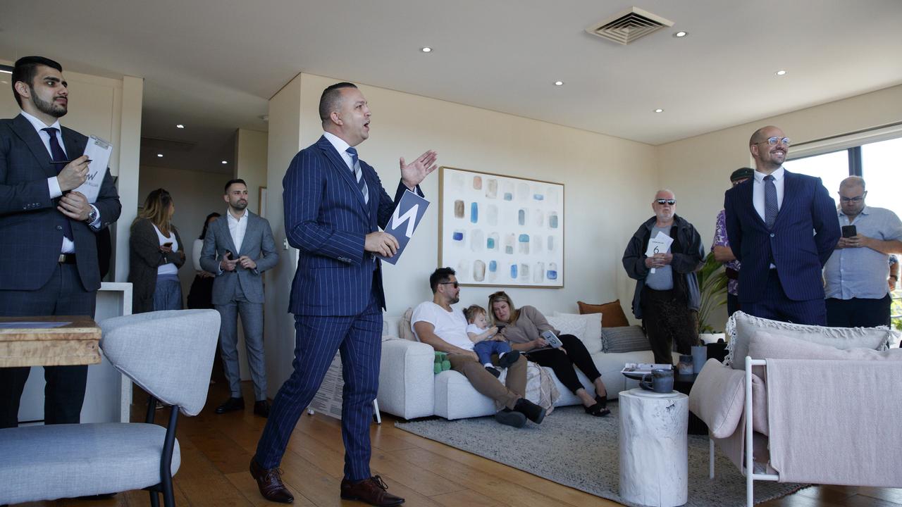 Auctioneer Clarence White (centre) at the Petersham unit. Picture: David Swift.