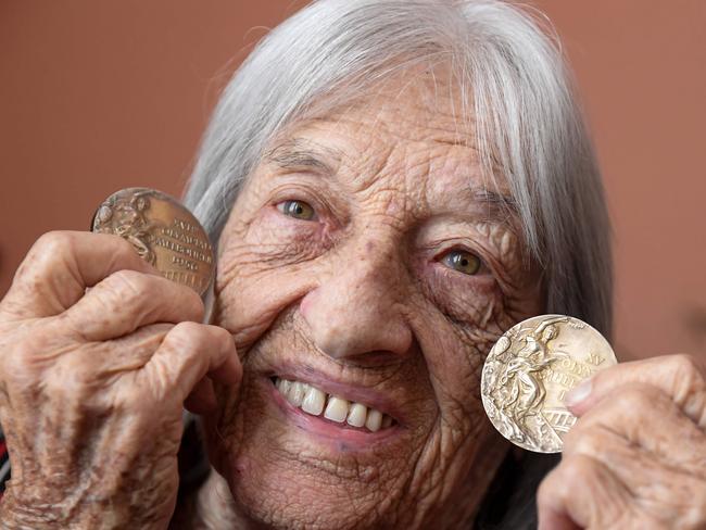 (FILES) In this file photo taken on November 11, 2020 Hungarian-Israeli retired Olympic and world champion artistic gymnast Agnes Keleti shows her first gold medal (R) won during the Olympic Games in Helsinki and her second one (L) won in Melbourne as she poses for photos in her apartment in Budapest on November 6, 2020. - Hungarian gymnast Agnes Keleti, the world's oldest living Olympic champion as well as a Holocaust survivor, will celebrate her 100th birthday on January 9, 2021. (Photo by ATTILA KISBENEDEK / AFP)