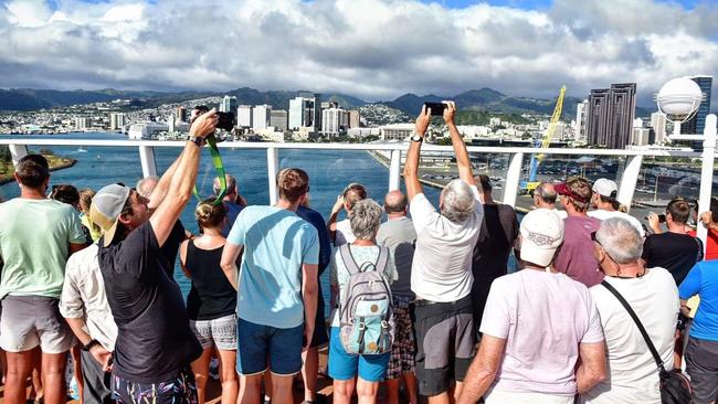 Passengers aboard the Norwegian Jewel cruise ship rejoice at seeing land of Honolulu, Hawaii, after spending several days at sea being refused entry at multiple ports over coronavirus fears. Picture: Tom Huntley