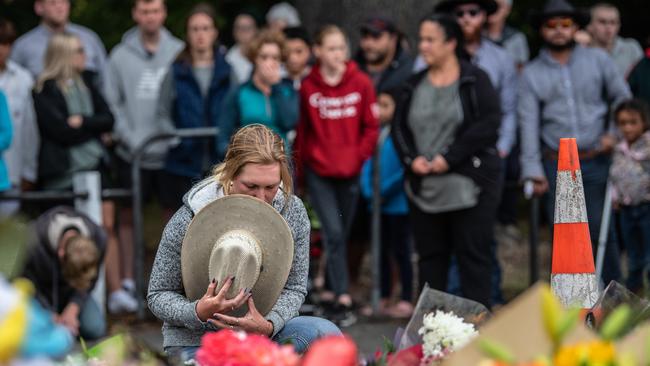 CHRISTCHURCH, NEW ZEALAND - MARCH 17: A woman holds her hat to her face as she pauses next to flowers laid near Al Noor mosque on March 17, 2019 in Christchurch, New Zealand. 50 people are confirmed dead, with 36 injured still in hospital following shooting attacks on two mosques in Christchurch on Friday, 15 March. 41 of the victims were killed at Al Noor mosque on Deans Avenue and seven died at Linwood mosque. Another victim died later in Christchurch hospital. A 28-year-old Australian-born man, Brenton Tarrant, appeared in Christchurch District Court on Saturday charged with murder. The attack is the worst mass shooting in New Zealand's history. (Photo by Carl Court/Getty Images)