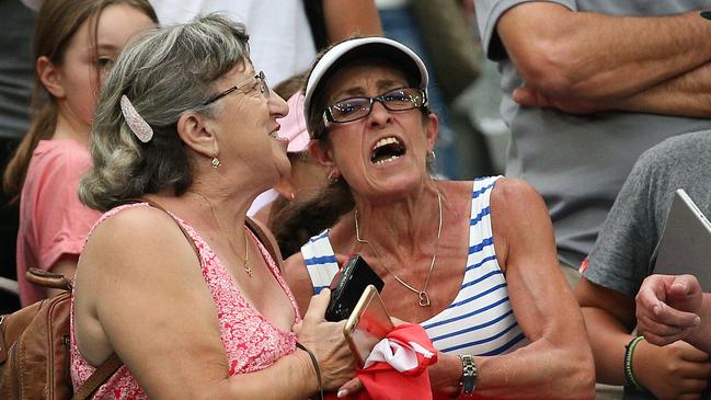 Two fans fight over Aryna Sabalenka's headband during day three of the Australian Open tennis tournament in Melbourne, Wednesday, January 16, 2019. (AAP Image/David Crosling) NO ARCHIVING, EDITORIAL USE ONLY (AAP Image/Hamish Blair) NO ARCHIVING, EDITORIAL USE ONLY