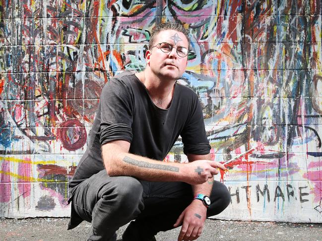 Artist Eamonn Miller of North Hobart in front of his mural  in Bidencopes Lane called Mendacity. Picture: Zak Simmonds