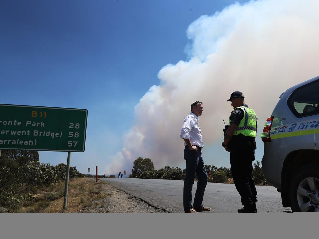 Police and Emergency Services Minister Michael Ferguson speaks to a police officer on Marlborough Road, Miena. Picture: LUKE BOWDEN