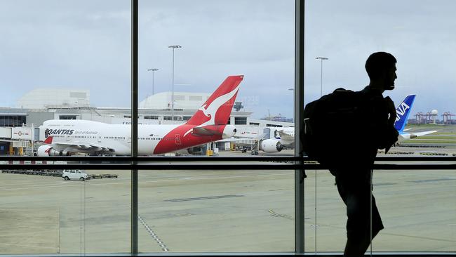 A passenger walks past a Qantas jet at the International terminal at Sydney Airport. Picture: Mark Evans/Getty Images.