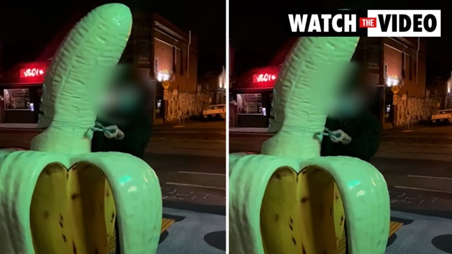 Person tries to saw top off controversial banana sculpture