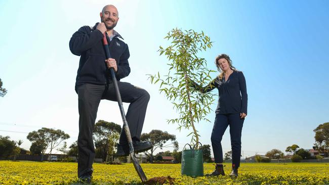 Onkaparinga sustainability co-ordinator Jenni McGlennon and senior urban forest officer Ian Seccafien plant a tree at a pocket park in Seaford, part of a program to increase tree cover. Picture: AAP / Brenton Edwards