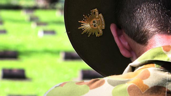 Sapper Joshua Knox from 2nd Combat Engineer Regiment pays respects while his 'rising sun' badge sits over a soldier's tombstone at Ambon war cemetery, Indonesia during Pacific Partnership 2010. Commonwealth and United States Defence personnel visited Ambon war cemetery in Indonesia during a recent break in Pacific Partnership 2010 activities. The cemetery, built on the site of a former camp for British, Dutch and Australian prisoners of war, has over 2000 graves with more than half of those being Australian.