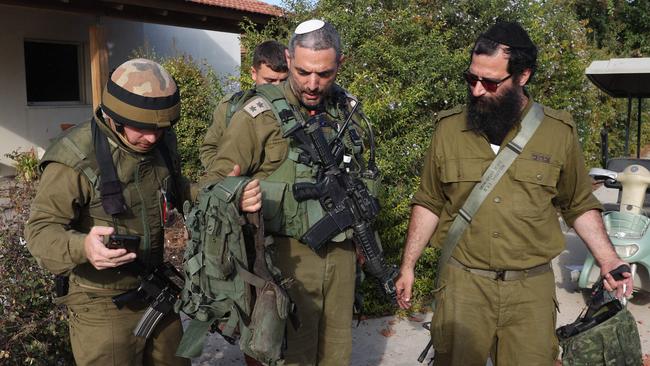 Israeli soldiers carry equipment which was used by Palestinian fighters in their attack at kibbutz Beeri near the border with Gaza on October 17, 2023. Picture: Jack Guez/AFP