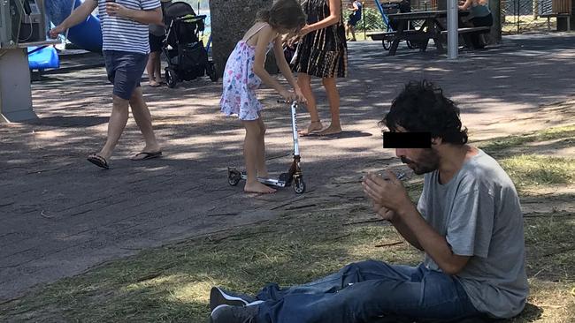 A man smokes synthetic acid only meters away from a kids playground on the main beach of Byron Bay Pic Nathan Edwards