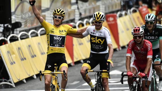 Tour de France winner Great Britain's Geraint Thomas and Chris Froome cross the finish line after an epic tour. / AFP PHOTO / Marco BERTORELLO