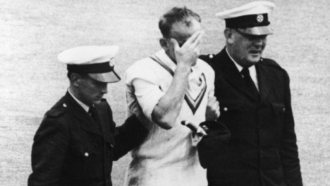 England fast bowler Frank Tyson is escorted from the fields after the blow.