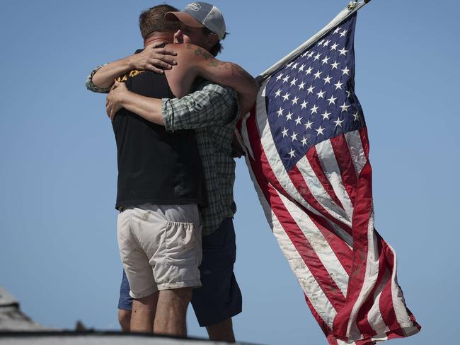 Whitney Hall (R) embraces a friend atop the remains of his home amidst wreckage left in the wake of Hurricane Ian on the island of Matlacha on September 30, 2022 in Matlacha, Florida. Picture: AFP