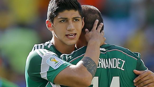 Alan Pulido consoles teammate Javier Hernandez after the Netherlands defeated Mexico in the 2014 World Cup.