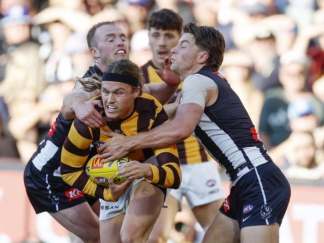 Jack Ginnivan of the Hawks tackled by Patrick Lapinski and Tom Mitchell. Picture: Michael Klein