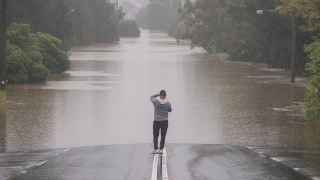 SYDNEY, AUSTRALIA - MARCH 23: A man stands on the main Windsor Road whilst taking photos in the suburb of McGraths Hill on March 23, 2021 in Sydney, Australia. Evacuation warnings are in place for parts of Western Sydney as floodwaters continue to rise. (Photo by David Gray/Getty Images) *** BESTPIX ***