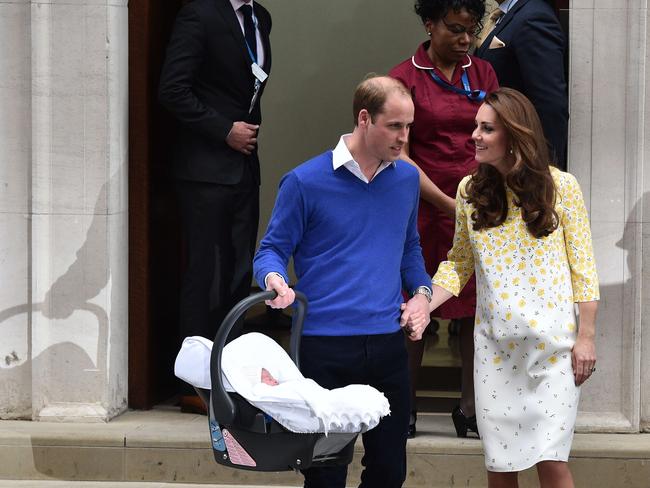 Britain's Prince William, Duke of Cambridge, carries his newly-born daughter, his second child, in a car seat as he walks with his wife Catherine, Duchess of Cambridge, away from the Lindo Wing at St Mary's Hospital in central London, on May 2, 2015. The Duchess of Cambridge was safely delivered of a daughter weighing 8lbs 3oz, Kensington Palace announced. The newly-born Princess of Cambridge is fourth in line to the British throne. AFP PHOTO / LEON NEAL