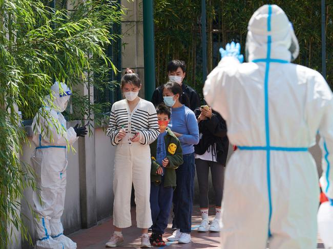 Residents queue to get tested for Covid-19 in a compound during lockdown in Shanghai. Children who test positive are being separated from their families. Picture: AFP