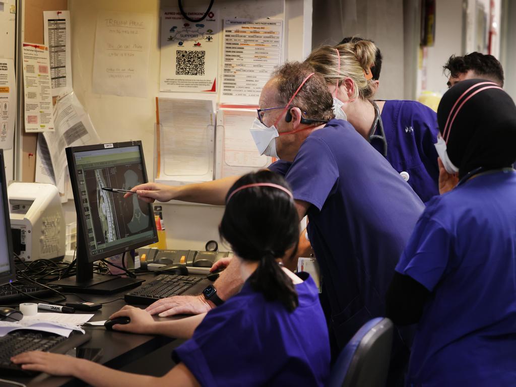 Professor Mark Fitzgerald examines a spinal scan with medical staff. Picture: David Caird