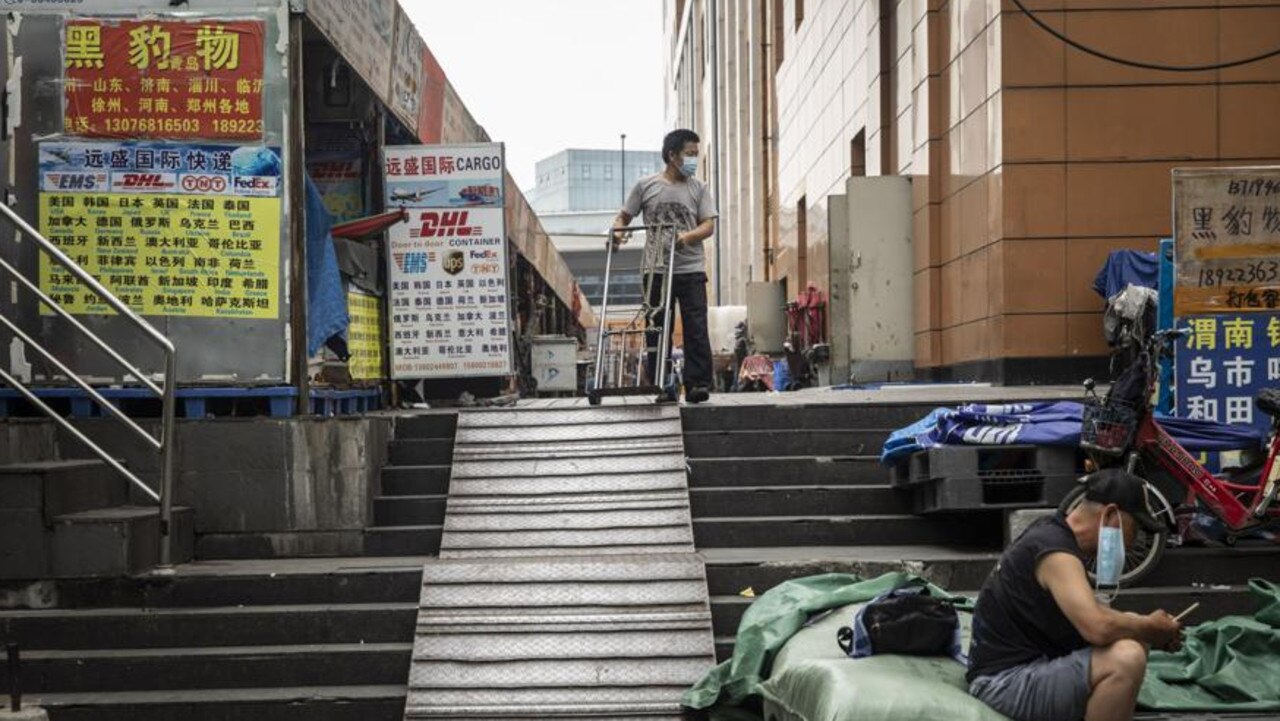 A porter wearing a protective mask stands outside of a wholesale mall in Guangzhou. Picture: Qilai Shen/Bloomberg