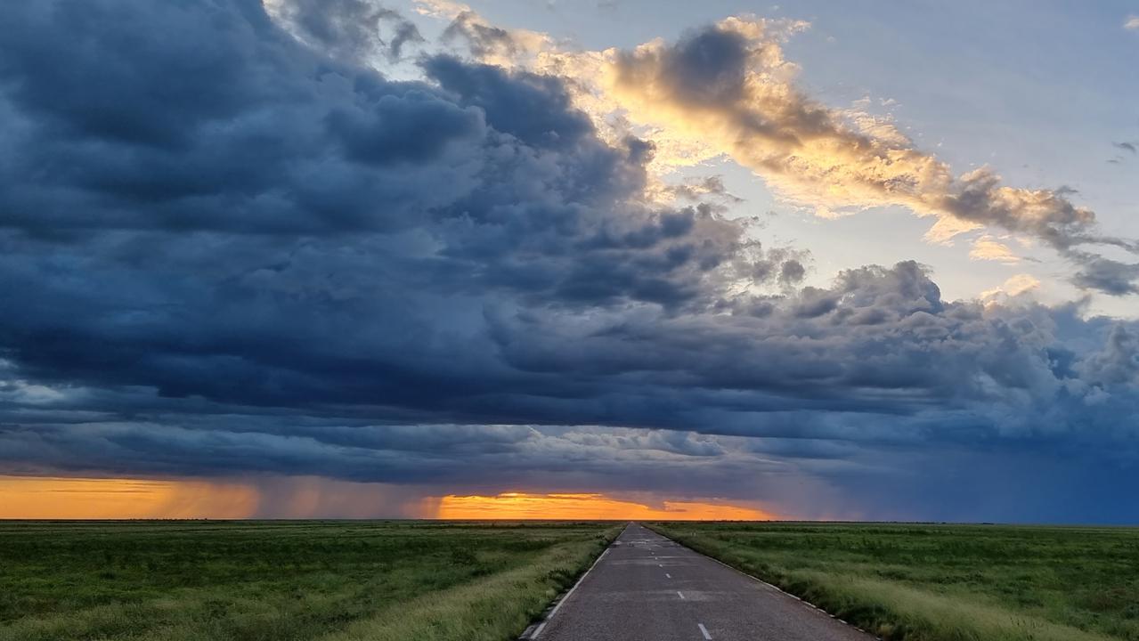 Sunset illuminates a brewing storm on a highway in the Northern Territory. See your best NT snaps here . Picture: Jordyn Ballantine