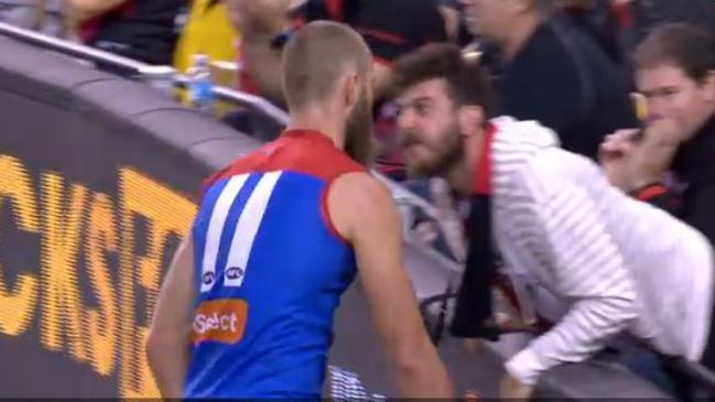 An Essendon fan gives Max Gawn a mouthful at Etihad Stadium.