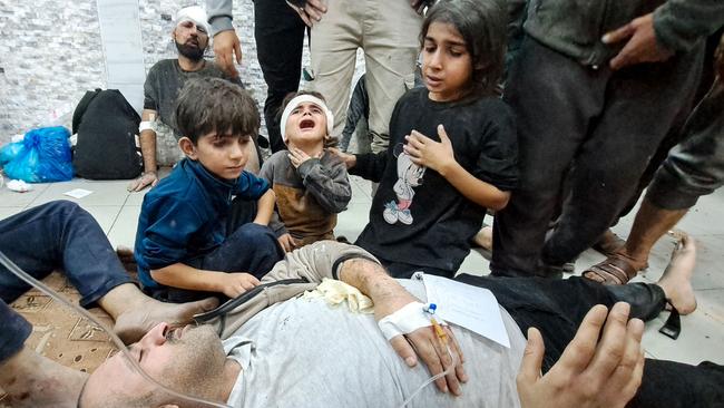 Palestinian children react near a wounded man at a hospital in Beit Lahia following Israeli bombardment on Tuesday. Picture: AFP