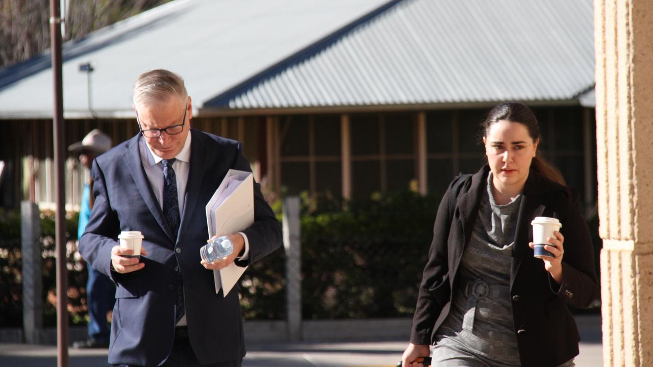 Lawyer representing the department of education for the commonwealth Matthew Brady (left) walks into Alice Springs Local Court. Picture: Gera Kazakov