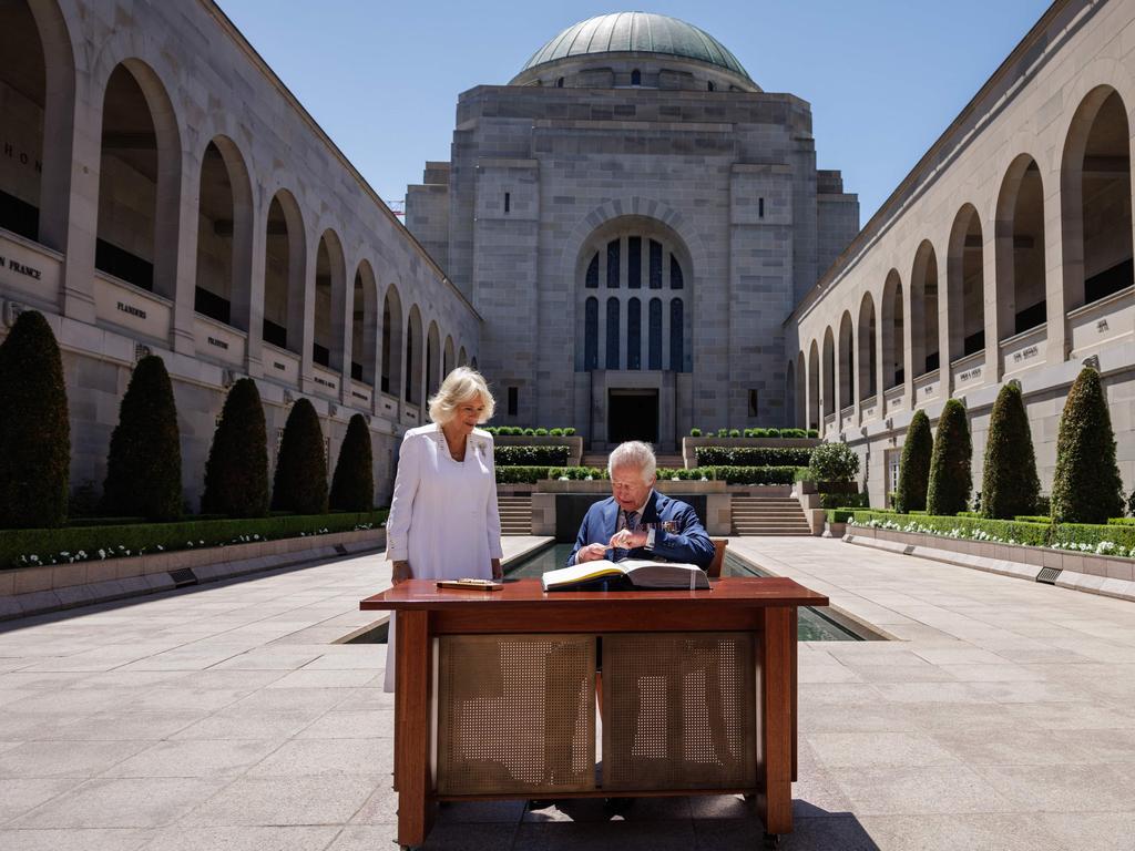 King Charles III signs the visitor's book as Queen Camilla looks on at the Australian War Memorial in Canberra on October 21. Picture: Brook Mitchell/POOL/AFP