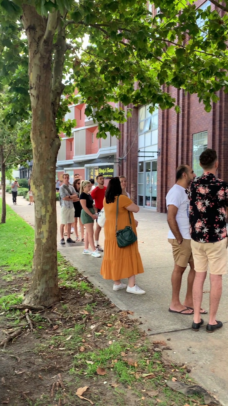 Dozens of people lined up in the hot sun to view the listings. Picture: Alice Fahrer