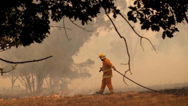 A CFS firefighter battles a fire as it runs across a paddock near a home on Ridge Road at Woodside in the Adelaide Hills in Adelaide, Friday, December 20, 2019. Picture: AAP Image/Kelly Barnes