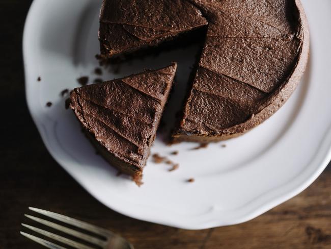 Whole sliced Chocolate cake with slice slightly removed. Photographed in window light with Nikon D800+50mm Zeiss Lens at ISO 100. Image Processed from raw file with VSCO Film Kodak Portra film simulation with film grain for a slightly more lo-fi look.