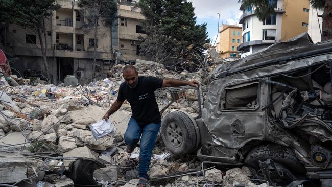 NABATIEH, LEBANON - OCTOBER 17: A man climbs over the rubble of a building that was hit by Israeli airstrikes, on October 17, 2024 in Nabatieh, Lebanon. Intense Israeli airstrikes in Nabatieh have left 16 people dead, including the city's mayor. Scores have been injured. (Photo by Carl Court/Getty Images)